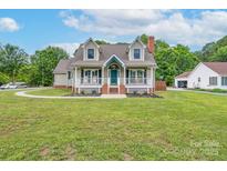 Charming two-story home with a well-manicured lawn, inviting front porch, and traditional architectural details at 1228 Quiet Acres Rd, Rock Hill, SC 29732