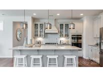 Bright kitchen features a large island with seating, stainless steel appliances, and pendant lighting at 13304 Chopin Ridge Dr, Huntersville, NC 28078