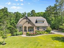 Beautiful brick home featuring well-manicured landscaping and a welcoming front porch at 15210 Pavilion Valley Cir, Huntersville, NC 28078