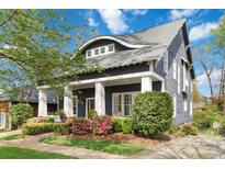 Charming home showcasing a meticulously landscaped front yard and inviting covered porch with classic columns at 1921 Brandon Cir, Charlotte, NC 28211