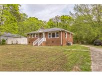 Charming brick home with a cozy front porch and ample green space at 2106 A Ave, Charlotte, NC 28216