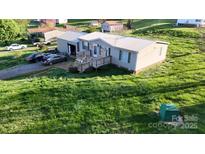 Charming single-story home with a metal roof, wooden deck, and well-maintained lawn at 3379 Appletree Ct, Vale, NC 28168