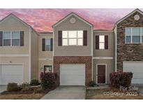 Charming townhome with neutral siding, a brick accent, and a one-car garage on a colorful sky background at 3623 Danvers St, Charlotte, NC 28213