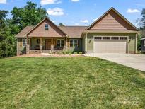 Charming home featuring a covered front porch, two-car garage and a well-manicured lawn at 575 Hill Rd, Lincolnton, NC 28092
