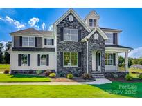 Charming two-story home with a stone facade, covered porch, manicured lawn, and beautiful architectural details at Tbd Boomer Ct # 9, Statesville, NC 28677