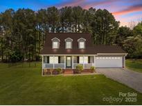 Charming home featuring a welcoming front porch and a well-maintained landscaped yard at 1228 Swift Rd, Oakboro, NC 28129