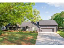 Charming single-story home with a well-manicured lawn, attached garage, and inviting front entrance at 235 Commodore Loop, Mooresville, NC 28117