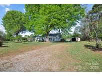 Exterior view of a home and lawn with mature trees and a detached garage at 2679 Providence Mill Rd, Maiden, NC 28650