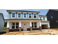 New two-story home with stone accents and covered front porch, enhancing curb appeal at 277 Supernova Dr # 12, York, SC 29745