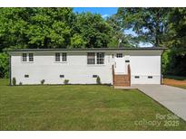 Charming single-story home features a fresh white paint, brick steps, and lush lawn at 3423 Archer Ave, Charlotte, NC 28217