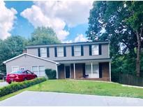 Charming two-story home with a well-maintained lawn, mature trees, and classic architectural details at 9404 Robert Burns Ct, Charlotte, NC 28213