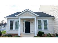 Inviting home entrance with black door, white pillars and trim, and well-maintained landscaping at 101 N Ferncliff Dr, Mount Holly, NC 28120