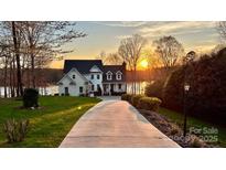 Inviting two-story home with a long driveway and manicured lawn at sunset at 272 Harbor Ridge Dr, Statesville, NC 28677