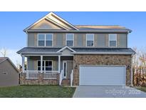 Charming two-story home featuring stone accents, a covered porch, and an attached two-car garage at 4176 River Run Cir, Hickory, NC 28602