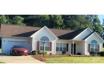 Charming single story home with brown roof, red shutters, lush lawn and a beautiful red vehicle in the driveway at 426 Summer Ridge Rd, Stanley, NC 28164