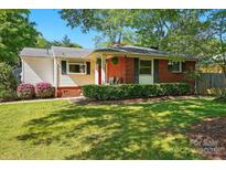Charming brick home featuring a well-manicured lawn and lush landscaping at 576 Scaleybark Rd, Charlotte, NC 28209