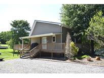 Charming home features a wooden deck, gravel driveway, and mature landscaping for a serene outdoor living space at 5769 Birch St, Conover, NC 28613