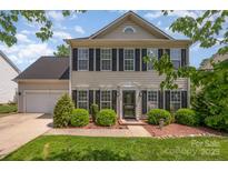 Charming two-story home with black shutters, landscaped yard, and attached garage. Beautiful curb appeal at 618 Circle Trace Rd, Monroe, NC 28110