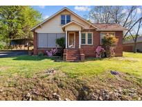 Charming brick home with mature landscaping and a covered parking area at 834 Murphy St, Kannapolis, NC 28081