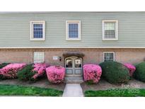 Attractive exterior shot featuring flowering shrubs, windows, and brick accents at 2630 Park Rd # H, Charlotte, NC 28209