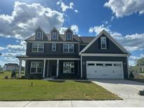 Beautiful two-story home featuring a two car garage, dormer windows, and professionally landscaped yard at 3214 Mcharney Dr # 34, Harrisburg, NC 28075