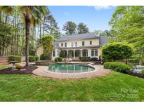 An inviting backyard featuring a refreshing pool and patio surrounded by lush landscaping at 4525 Island Waters Dr, Denver, NC 28037