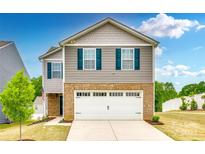 Charming two-story home featuring a brick facade, gray siding, blue shutters, and a pristine white garage door at 5014 Fandango Rd, York, SC 29745