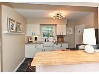 Modern kitchen features white cabinets, granite countertops, and undermount sink at 557 Wakefield Dr # A, Charlotte, NC 28209