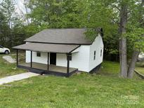 Charming one-story home with a covered porch and a lush, green yard at 59 Pine St, Great Falls, SC 29055