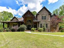 Stunning brick home with beautiful landscaping and a winding walkway leading to the front door at 633 Elmhurst Dr, Fort Mill, SC 29715