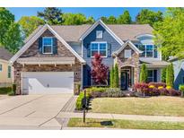 Charming two-story home with stone accents, manicured lawn, and mature landscaping at 826 Coralbell Way, Fort Mill, SC 29708