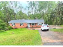Charming brick home with a metal roof, black shutters, and a well-maintained lawn at 2116 Dana Pl, Shelby, NC 28152