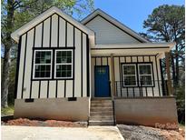 Striking exterior of a modern home featuring bold black and white vertical siding and a bright blue front door at 2350 14Th Street Ne Ct, Hickory, NC 28601
