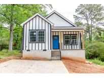 Charming white home with striking black trim, a bright blue front door, and newly poured concrete driveway at 2350 14Th Street Ne Ct, Hickory, NC 28601