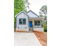 Charming new build home with a striking blue door, white siding, and black trim nestled in a leafy setting at 2350 14Th Street Ne Ct, Hickory, NC 28601
