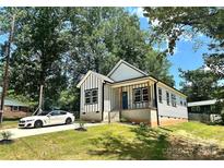 Beautiful home with a front porch, dark trim, manicured lawn and a modern white car in the driveway at 2350 14Th Street Ne Ct, Hickory, NC 28601