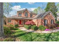 Charming two-story brick home with a red front door, manicured landscaping, and inviting curb appeal at 255 Fernbrook Dr, Mooresville, NC 28117