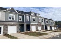 New townhomes with stone accents, garages, modern windows, and professional landscaping at 2579 Ruby Dixon Crossing Dr # 12, Gastonia, NC 28056