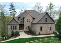 Charming brick home with manicured lawn, stone accents, and mature trees creates a welcoming curb appeal at 2757 Trent Ne Dr, Conover, NC 28613
