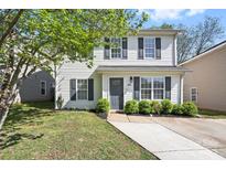 Charming two-story home with light siding, black shutters, manicured lawn, and freshly-laid landscaping at 415 French St, Charlotte, NC 28216