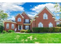 Charming brick home featuring a well-manicured lawn, mature landscaping, and classic architectural details at 4333 Sawmill Trace Dr, Charlotte, NC 28213
