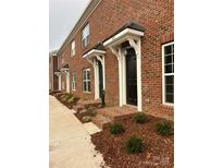 New brick townhouse with black front doors and manicured landscaping at 439 Beacon Nw St, Concord, NC 28027