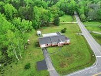 Stunning aerial shot of a well-maintained home with ample yard space and a detached shed at 4462 Flat Creek Rd, Heath Springs, SC 29058