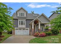 Charming two-story home with a well-manicured lawn, attached two-car garage, covered porch, and neutral color palette at 911 Naples Dr, Davidson, NC 28036