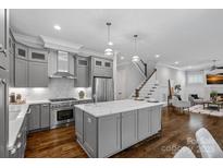 Bright, open kitchen with gray cabinets, marble countertops, stainless steel appliances, and a central island at 911 Naples Dr, Davidson, NC 28036
