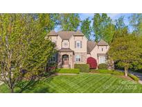 Charming home boasts manicured lawn, stone accents, and mature trees at 9927 Clarkes View Nw Pl, Concord, NC 28027