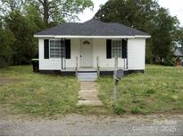 Charming single-story home with a welcoming front yard and black shutters on a partially cloudy day at 1230 Roberts St, China Grove, NC 28023