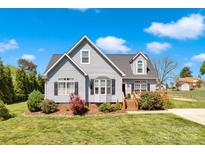 Charming two-story home featuring gray siding, a well-manicured lawn, and a welcoming front porch at 126 Top Flite Dr, Statesville, NC 28677