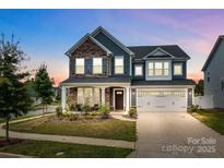 Beautiful two-story home with stone accents, a well-manicured lawn, and a two-car garage in a lovely neighborhood at 12710 Es Draper Dr, Huntersville, NC 28078