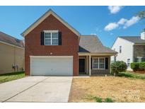 Charming two-story brick home with a two-car garage and well-maintained front yard at 1409 Rheo Nw Ct, Concord, NC 28027